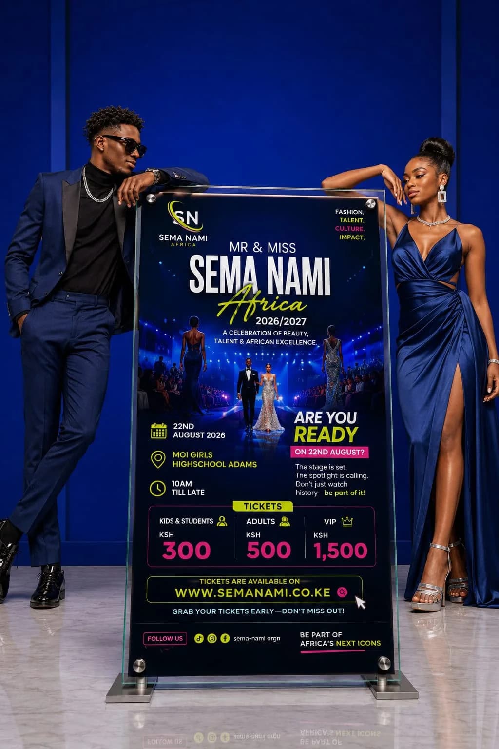 Two models in navy formalwear beside the Mr & Miss Sema Nami Africa banner stand